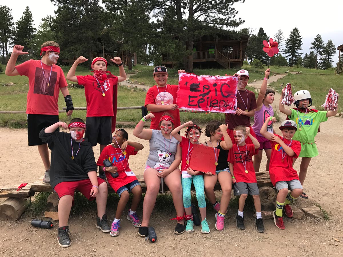 Group of campers posing for a photo, flexing arm muscles