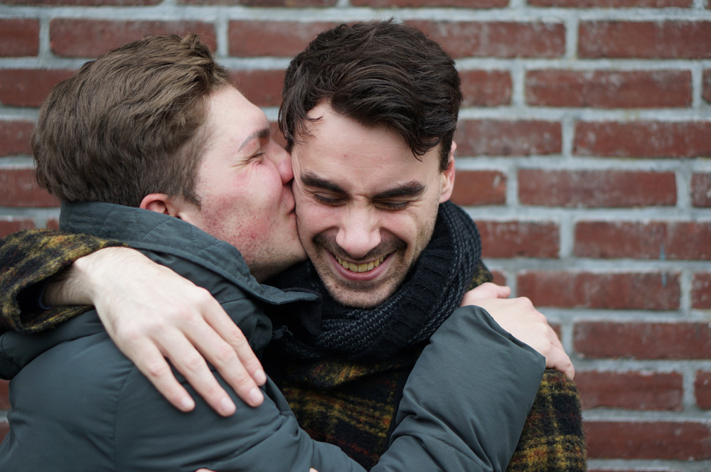 Two men smiling and embracing