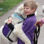 A boy hugging a dog at the Walk to End Epilepsy 5K