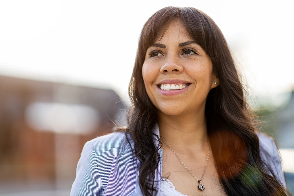 Smiling woman outdoors in a professional portrait, representing confidence, wellness, and treatment options